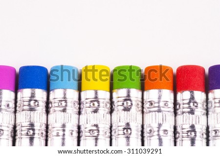 Closeup of Brightly colored pencil erasers in a straight pattern