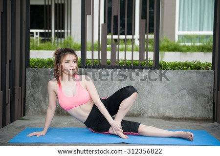 Portrait of young woman doing physical exercise in park