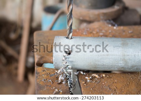 Metal drilling with a large drill in a workshop