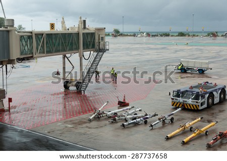 Phuket, Thailand - June 15, 2015: Airport\'s staff working on security check on a bad weather in monsoon season