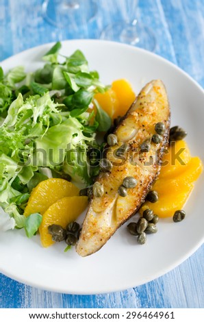 Fish steak with citrus marinade and capers, served with lettuce and oranges