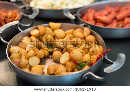 Skillet with saute potatoes in a breakfast buffet.