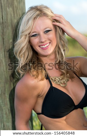 Young caucasian woman laughing and looking at camera in bikini outdoors