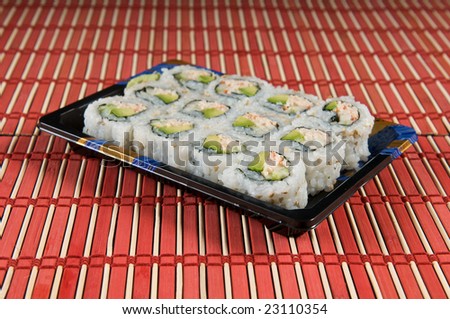 California Roll Sushi Tray over natural bamboo background. Use of selective focus on the foreground.