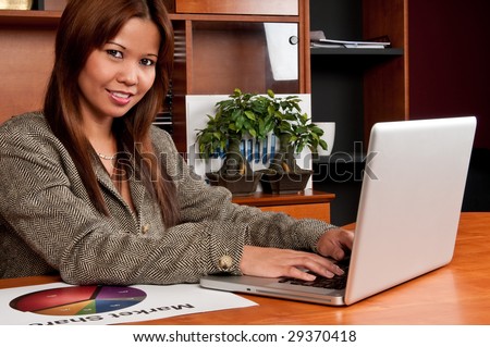 Young worker in an small office enviroment setting working in laptop.