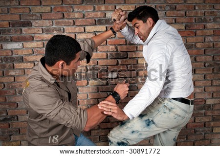 Young guys fighting in the street with knifes.