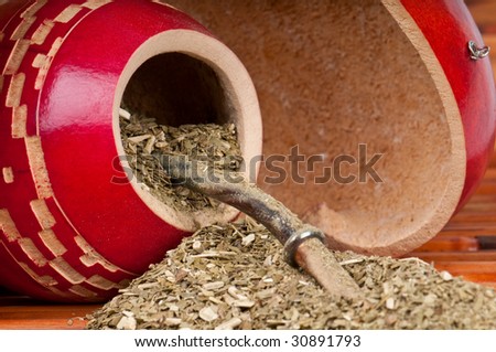 Close up of calabash cup with spill of yerba mate tea and straw. Use of Selective Focus.