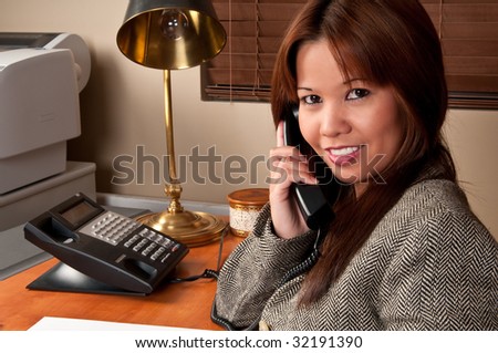 Young executive woman in small business talking in the phone.