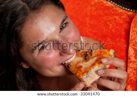 Young woman very happy eating a slice of pizza.