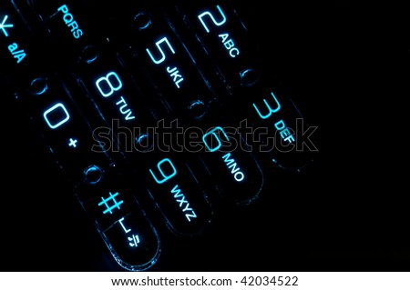 Close up view of a cell phone keypad backlit.