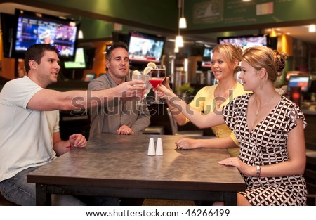 Young friends  in a modern bar and lounge toasting.