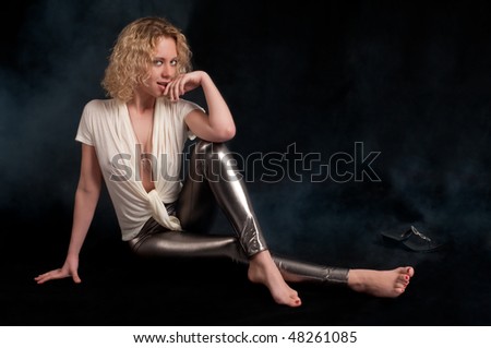 Young caucasian woman with curly hair seated with sensual pose.