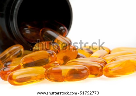 Close up view of Omega 3 pills, spilling from bottle. Use of selective focus.