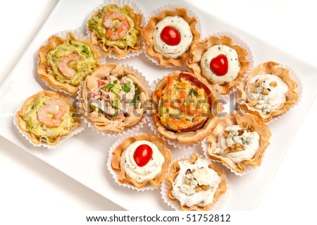 Tray full of volauvent canapes ready to serve. Volauvent is a tiny round canape made of puff pastry. The term \' vol au vent \' means \' blown by the wind \' in French.