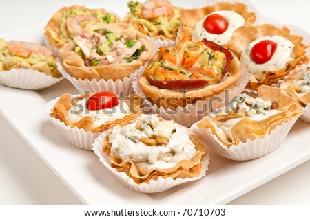 Tray full of volauvent canapes ready to serve. Volauvent is a tiny round canap made of puff pastry. The term \' vol au vent \' means \' blown by the wind \' in French.