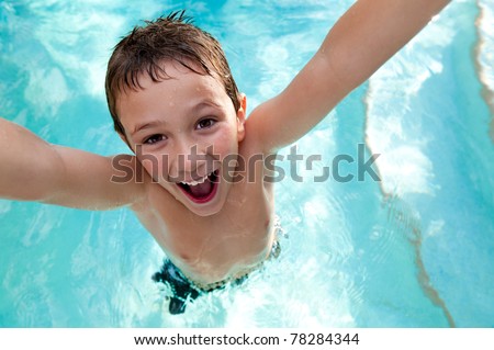 Portrait of kid very playful and jumping in a swimming pool.