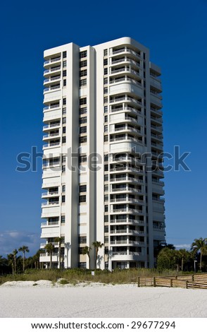 A beautiful Art Deco inspired condominium tower, over a deep blue sky.