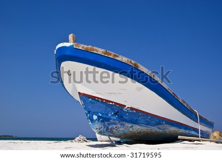 stock photo : An old weathered fishing boat on a Caribbean beach