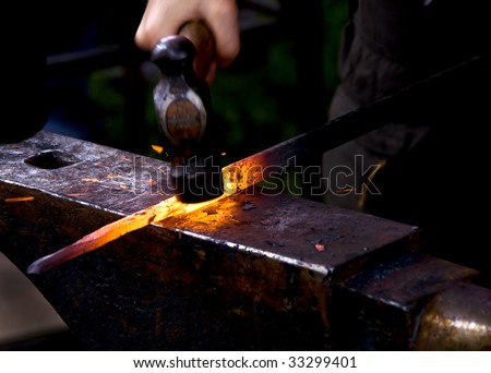 A blacksmith hammering a hot metal rod to shape it.