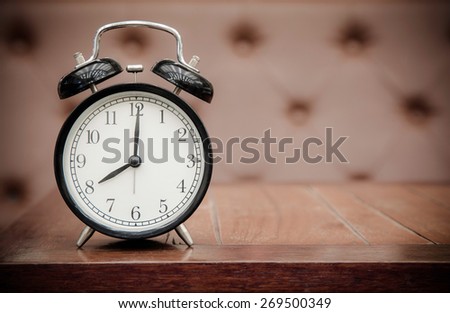Vintage background with retro alarm clock on table upholstery leather pattern background