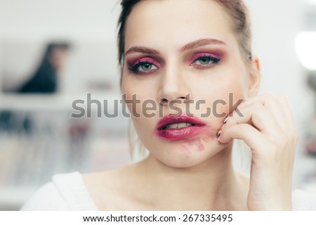 The girl with the smeared lipstick . Studio portrait.