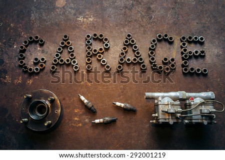 inscription Garage made of nuts and some automobile spare parts. Conceptual photo. Rusty metal background.