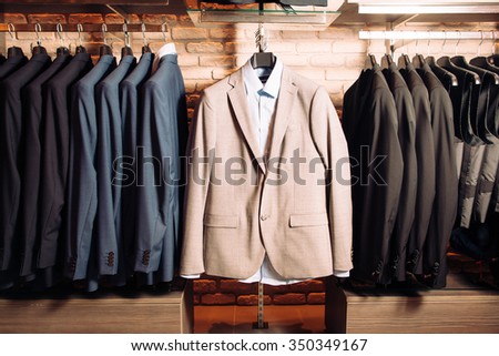 Many men\'s business suits of different colors. Modern boutique with clothes for business people. Horizontal photo