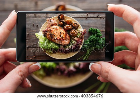 Food photography of baked pork with fresh vegetables. Home made food photo for social networks. Top view mobile phone photo of baked meat.