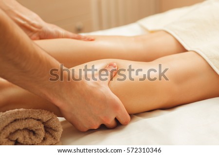 Professional masseur massaging female legs. Relaxing spa procedures, whole body massage, free space. Pleasure, rest, body care, beauty, alternative medicine, stress relief concept