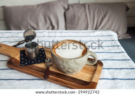 Hot Latte Coffee and syrup put on the corner of image, with pillow background