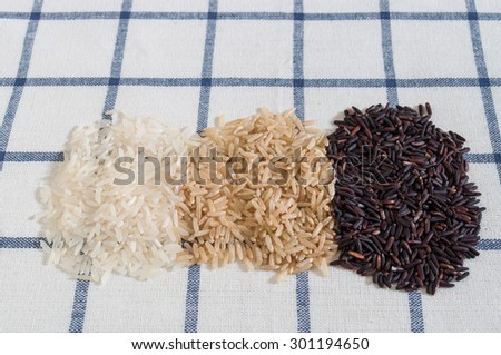 Food background with three groups of rice varieties on table cloth background