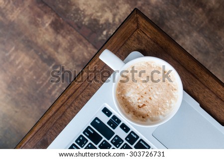 Working time with hot caramel macchiato coffee on angle of laptop