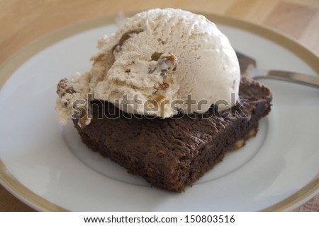 chocolate brownie with vanilla ice cream ball and nuts dessert
