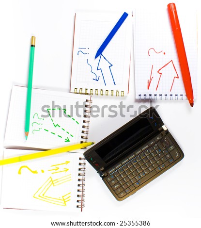 Open palmtop opposite four notebooks with felt-tip pens, crayon and wax pencil