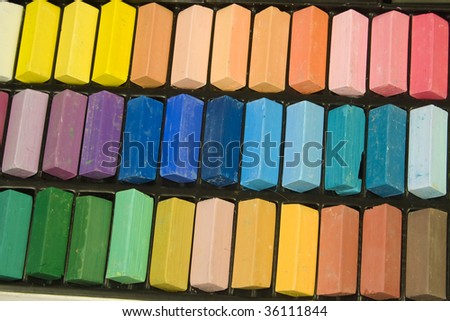 Rows of pastel colored chalk in a chalk tin.