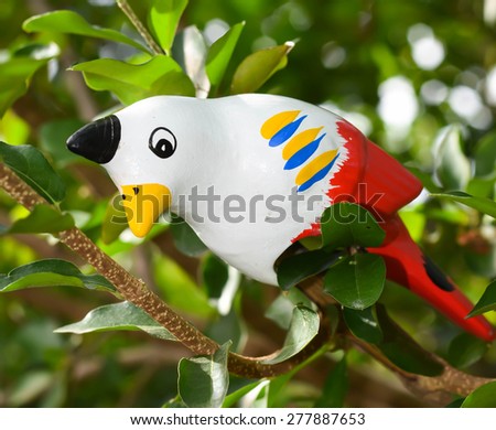 Clay white bird perched on a branch