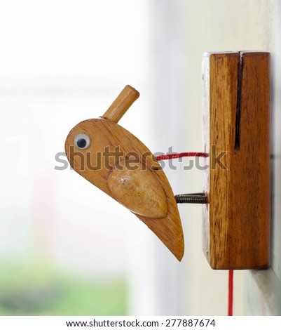 Wooden bird for children. For guests who came to visit a friend\'s house . By pulling the rope to make wooden bird knocked to the base of it like a knock on the door.