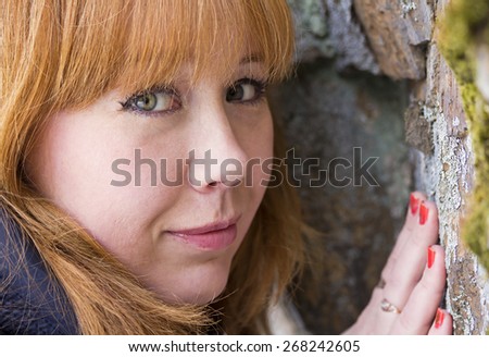 The red-haired girl touches the stone in career.