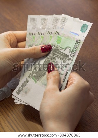 Female hands holding Russian banknotes of one thousand rubles.