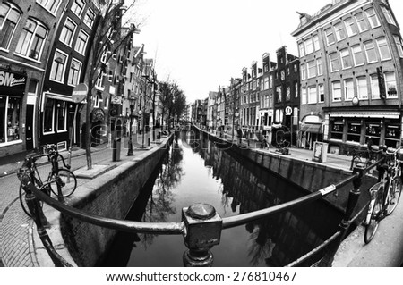AMSTERDAM, NETHERLANDS, MARCH 16, 2013: Black and white photography of Amsterdam street with a river taken from a bridge with fish-eye lens