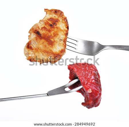 Grilled pork meat and raw beef meat on a fork isolated on a white background
