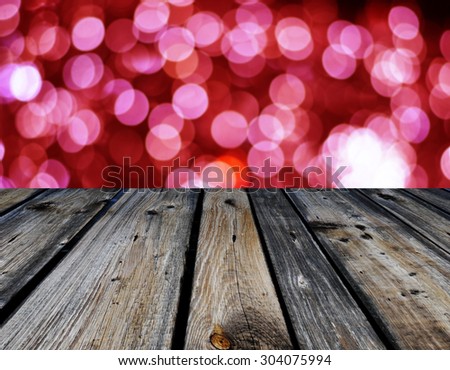 Red Christmas bokeh with wooden table in the foreground