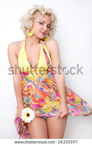 young beautiful woman with curly hair smiling and holding flower