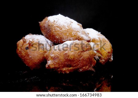 Pile of Dutch donut also known as oliebollen, traditional New Year\'s eve food isolated over black background