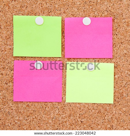 Blank sticky notes pinned on cork memo board in closeup