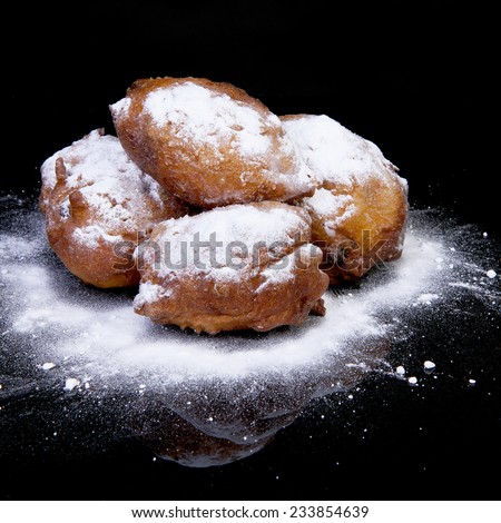 Pile of Dutch donut also known as oliebollen, traditional New Year\'s eve food isolated over black background
