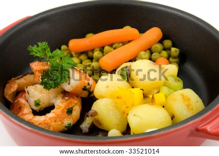 red pan with meal: potatoes, shrimp, peas and carrots, isolated on white background