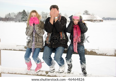three people in snow showing speak, see and hear no evil