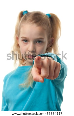 Young blonde girl is pointing at you with focus on fingers an blur on face, over white background