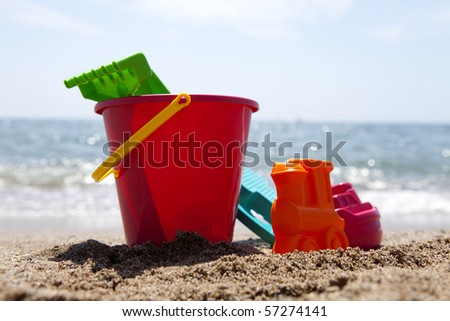 plastic toys at the beach against blue sky and ocean
